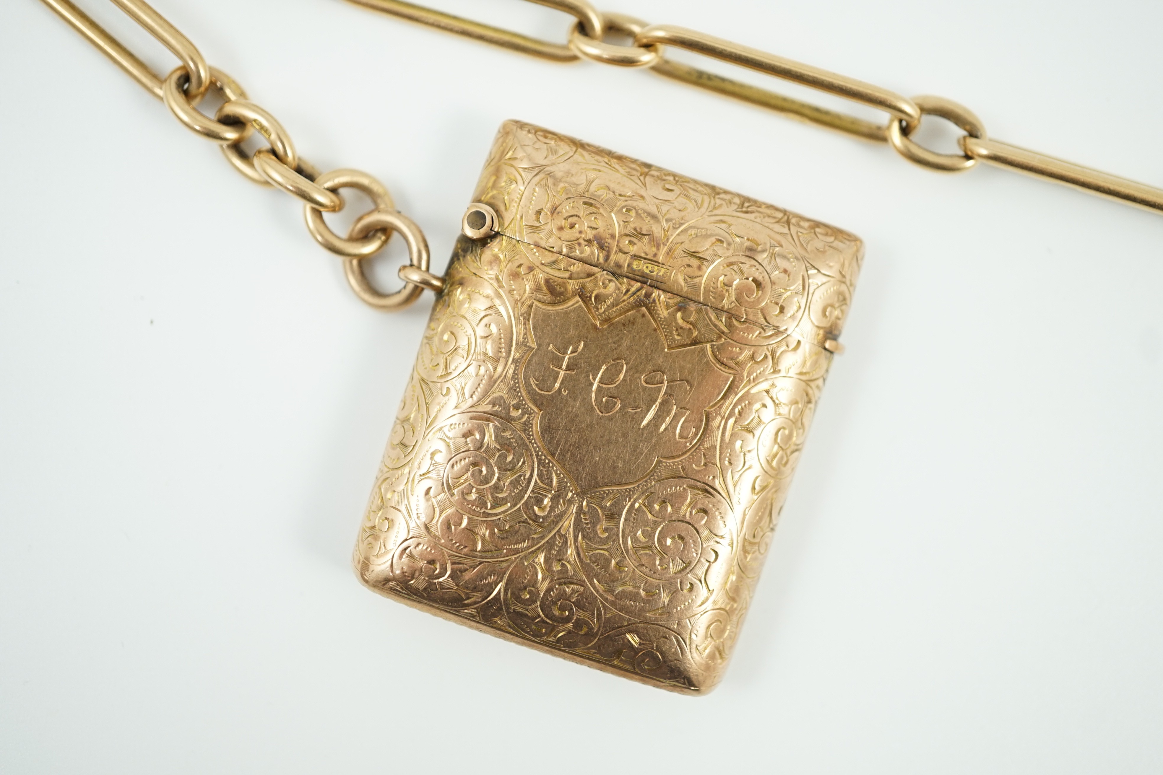 An Edwardian engraved 9ct gold vesta case, 44mm, gross 20.6 grams, together with an 18ct gold albert, 34cm, 45.8 grams.